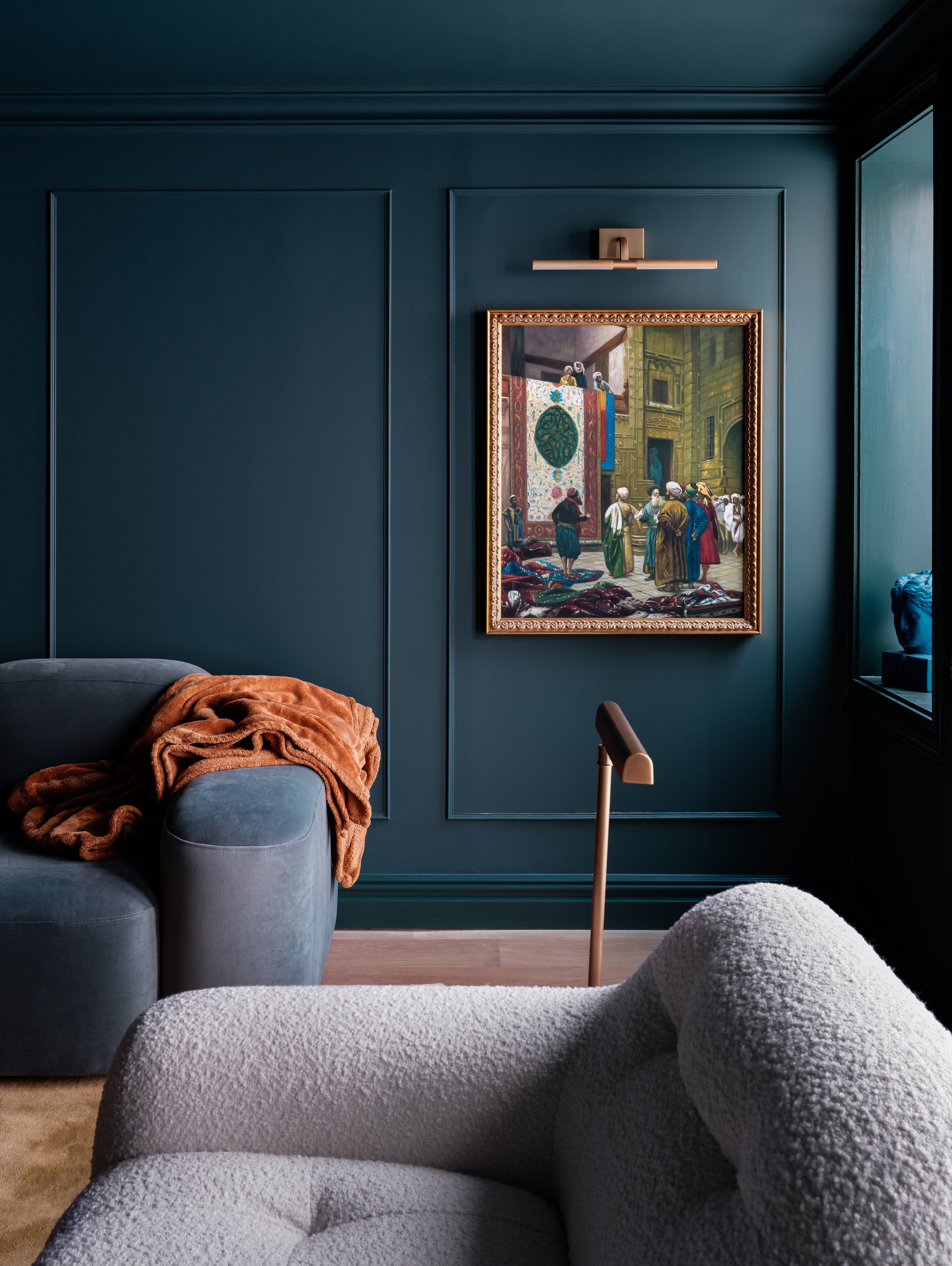 Marine blows living room with low sofas and wall art, which is exhibited in an artistic frame in ancient style