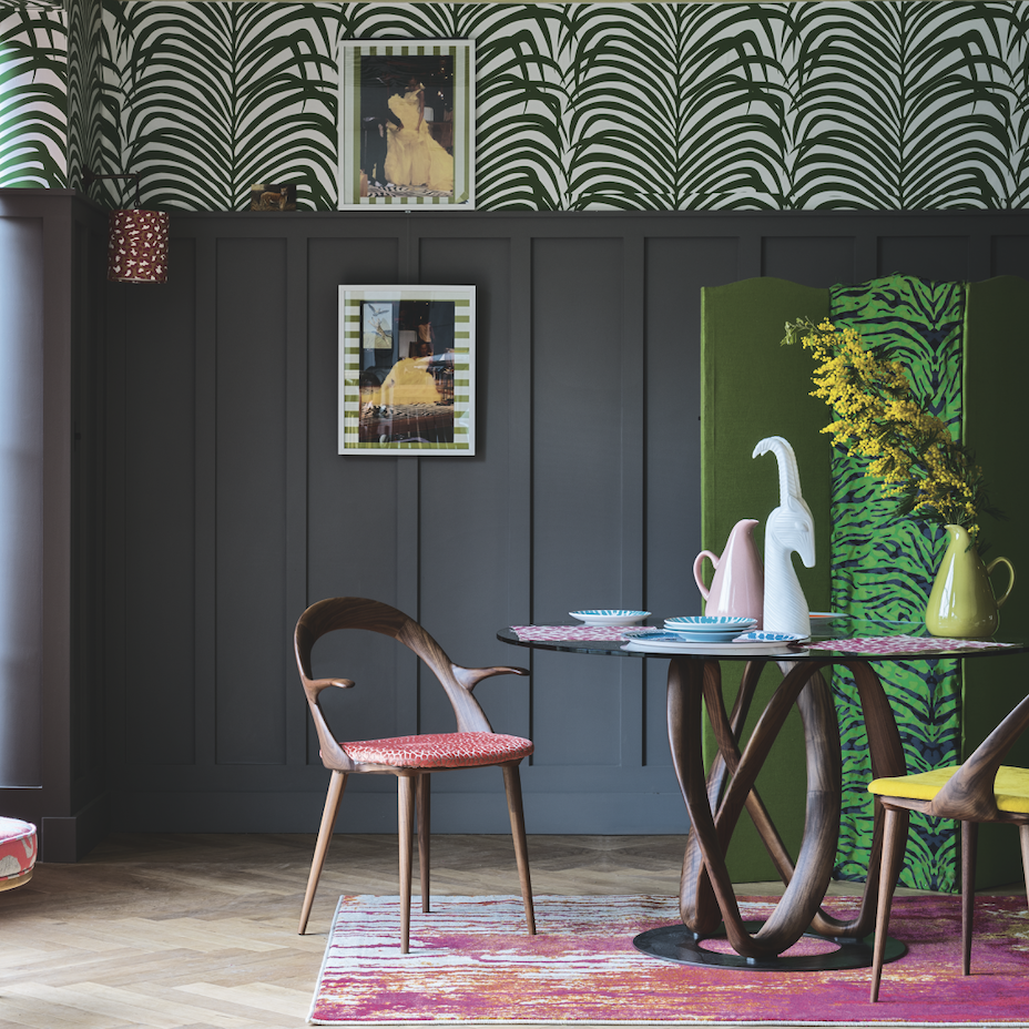 A gray room with painted strips on the wall and a green and blue screen in the zebra style