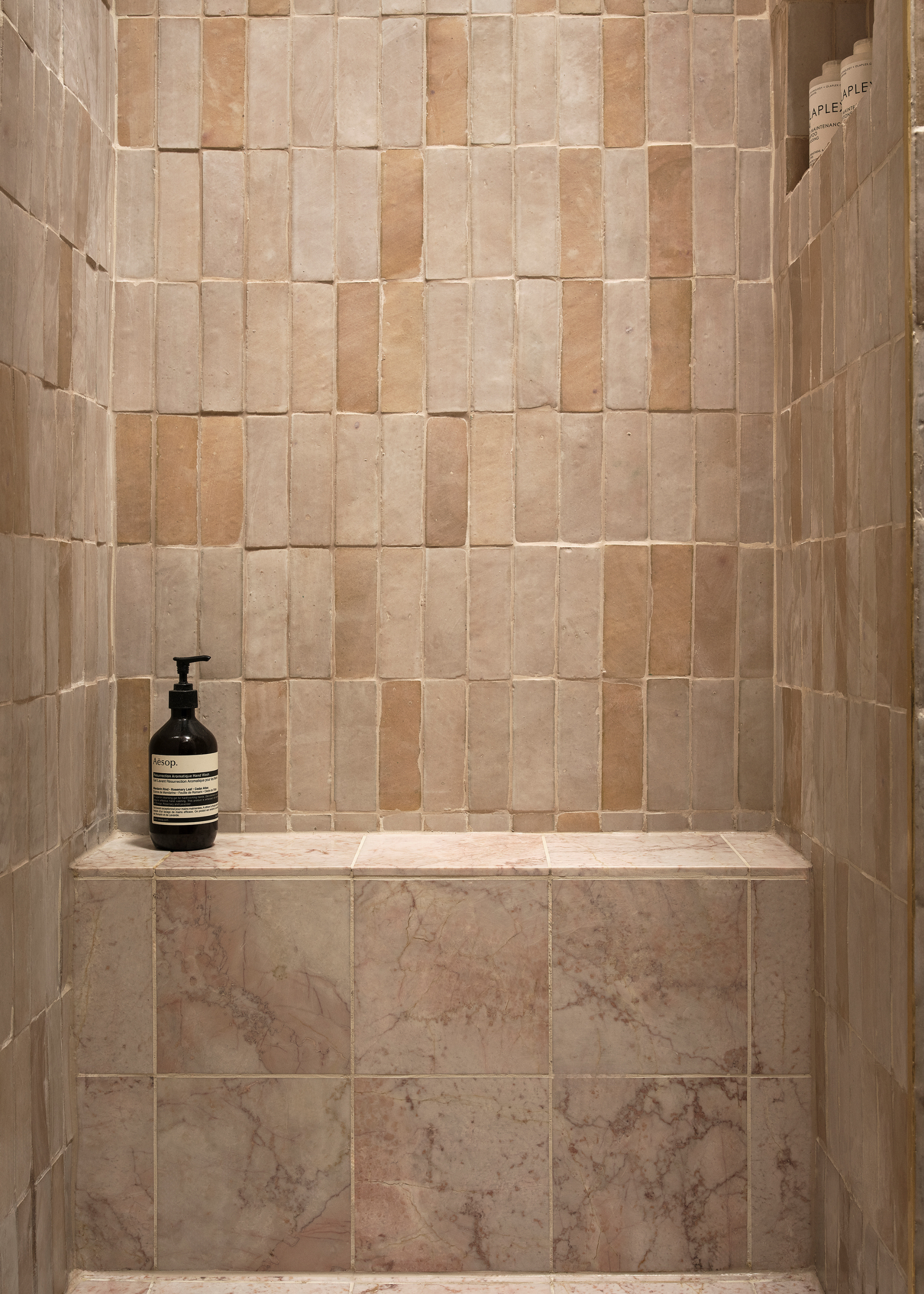 Naked tiled shower with a marble tile seat