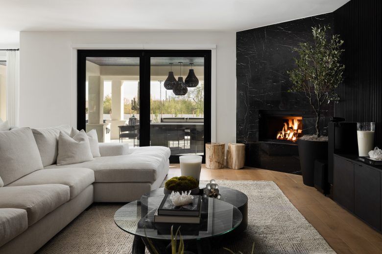 An informal living room with a white couch and a dark stone fireplace.