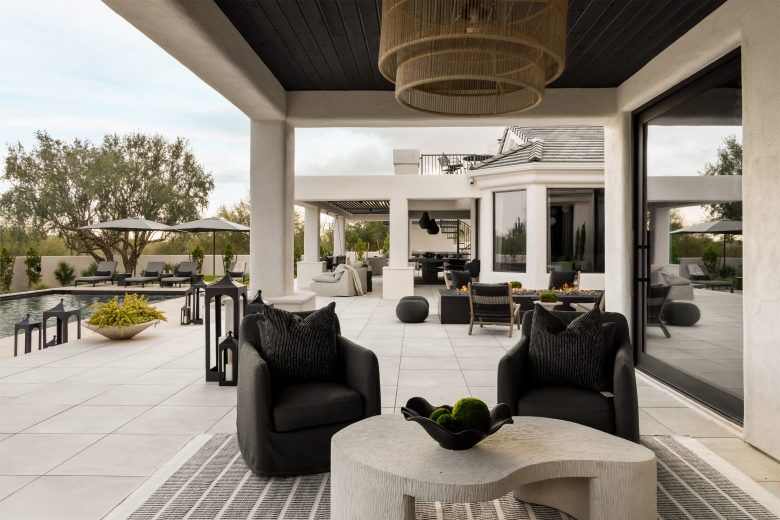 A seating area outdoors with dark chairs and a white coffee table.