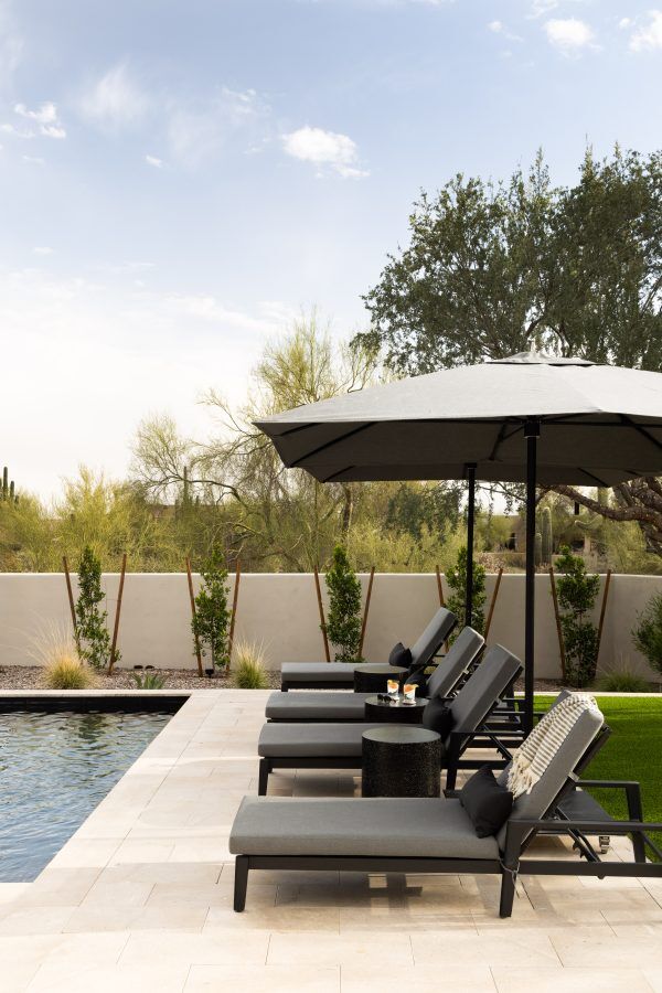 Outdoor chairs outdoors through a rectangular pool.