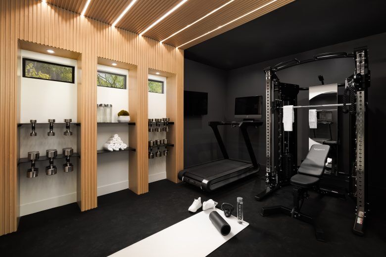 A home fitness studio with treadmill and weights.