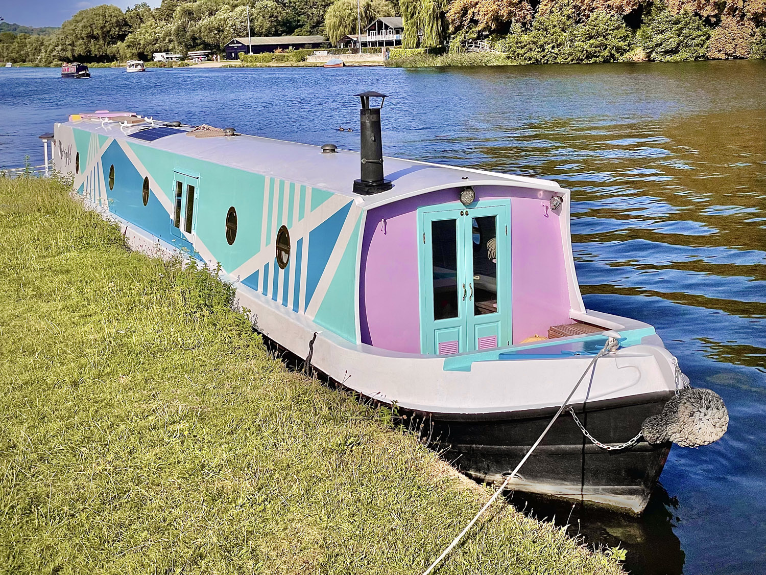 A narrow boat with a pastel voletting, blue and white geometric design.