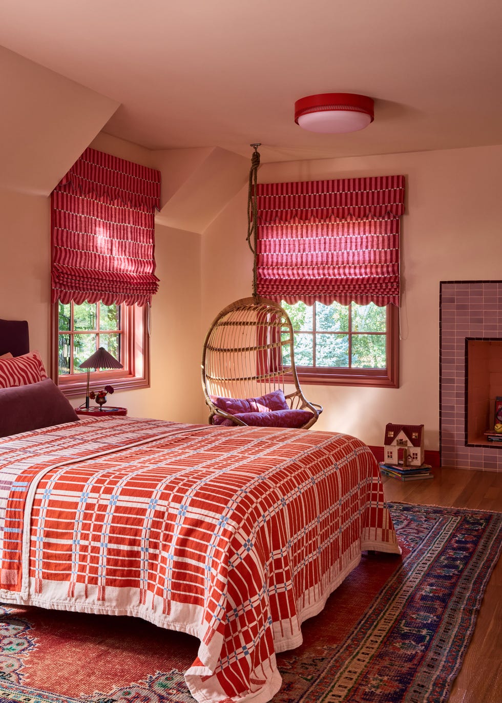 Cozy bedroom with a woven chair and patterned bed linen.