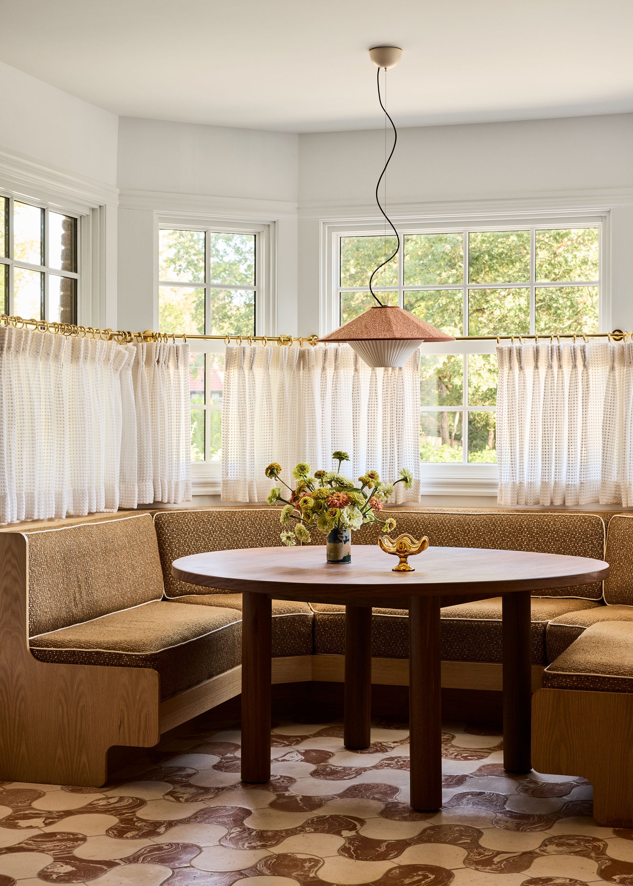 Cozy dining area with a round table and padded corner seat.