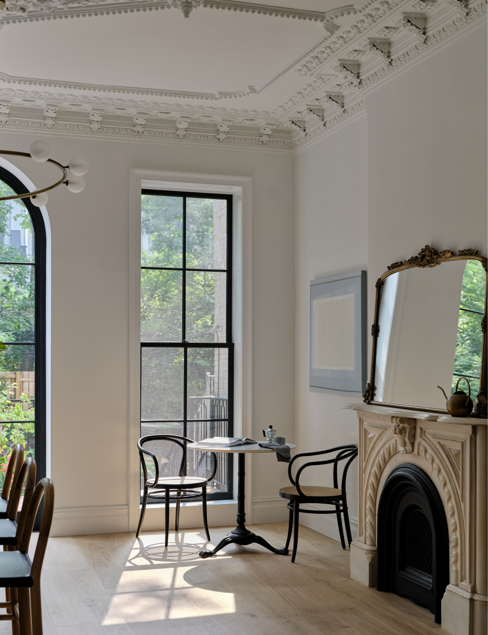 Large, sunlit dining room with decorated shape and a stone fireplace