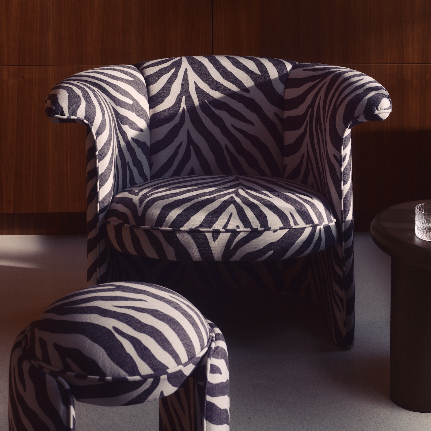 A zebra print armchair with a suitable footstep