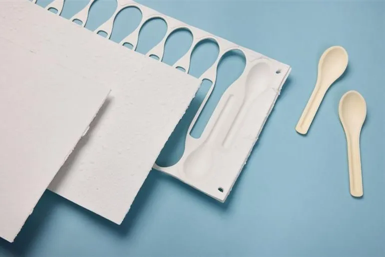 Two spoons that are cut out of the white board
