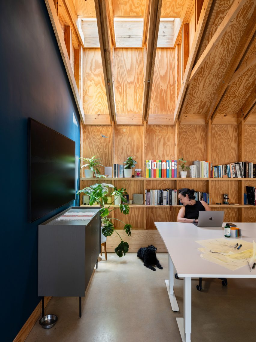 The architect's studio with a skylight above and shelves behind a white desk