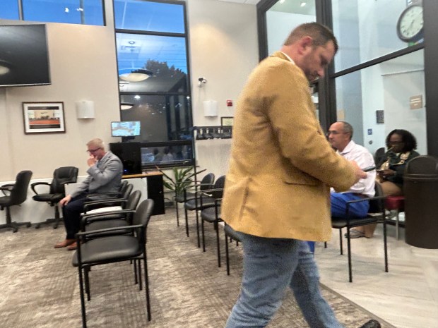 A DealPoint Merrill representative leaves the council chambers Oct. 28 to call California headquarters to confirm a change to the fence plan. (Frank Mecham-The News-Herald)