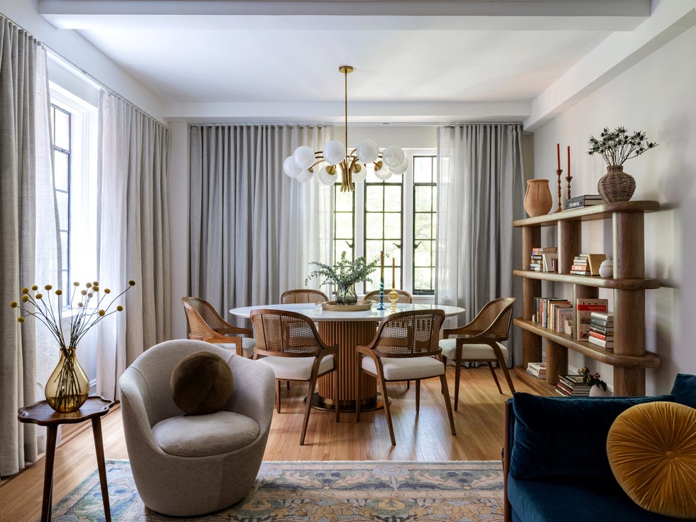 an open formal dining room with wooden furniture and gray floor-to-ceiling curtains