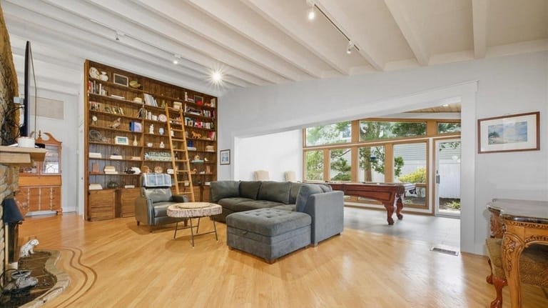 A floor-to-ceiling bookshelf with rolling ladder "gives the house...