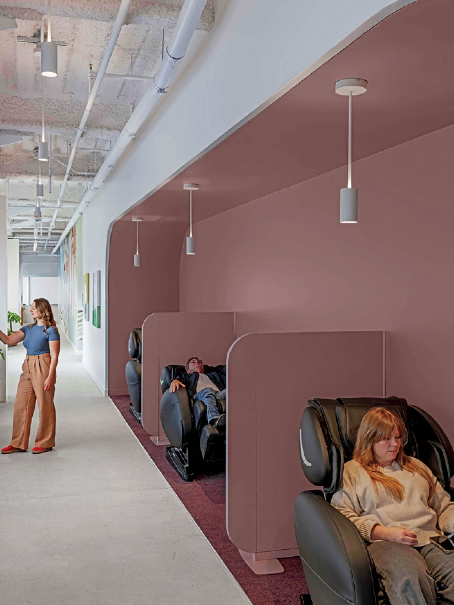 A woman sits in a massage chair in a room