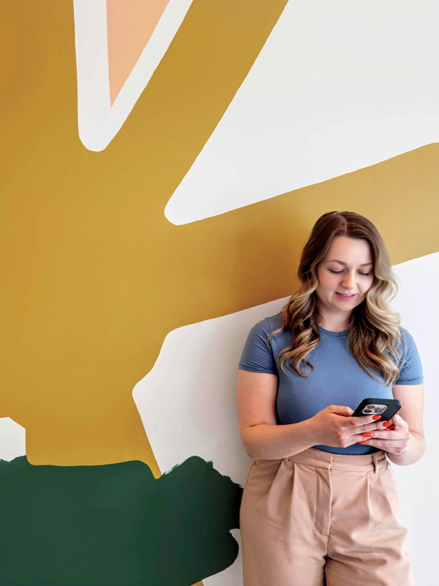 A woman stands in front of a wall with a cell