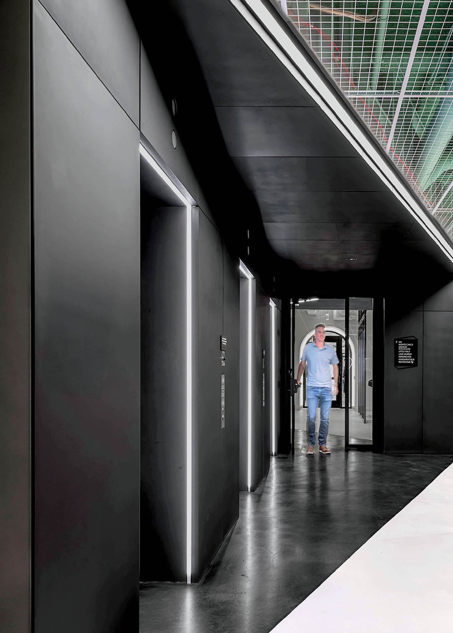 A man walks down a long hallway.