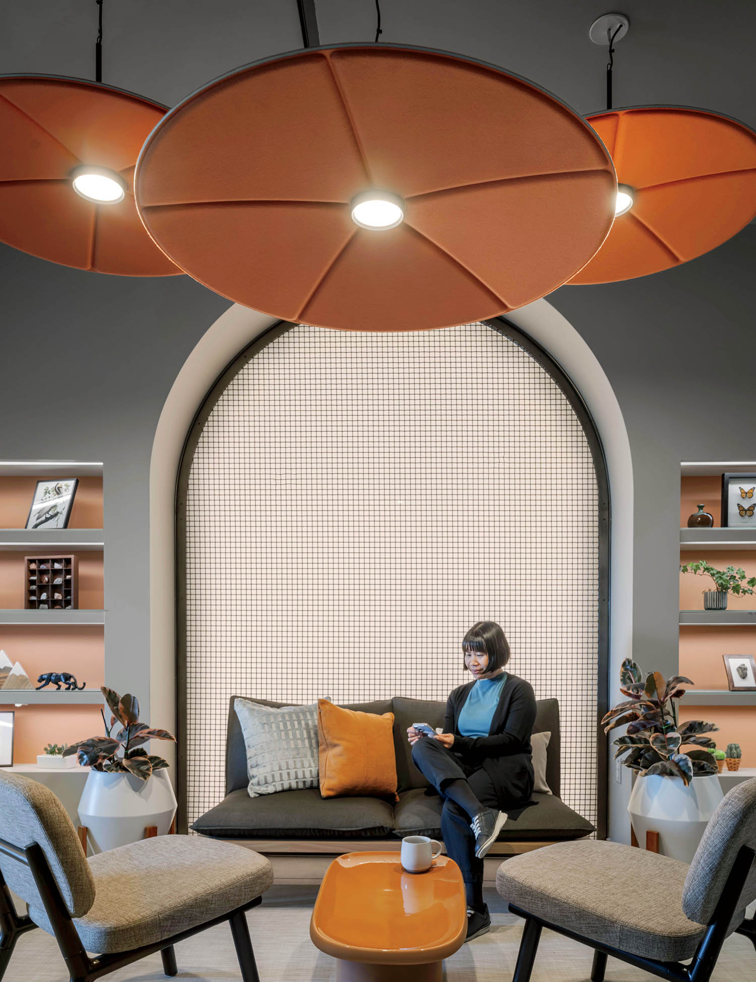 A woman sits on a couch in a room.