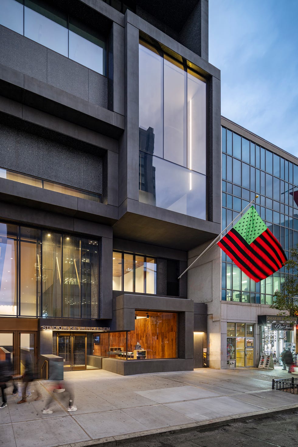 Modern architectural building with large glass windows and a colorful flag.