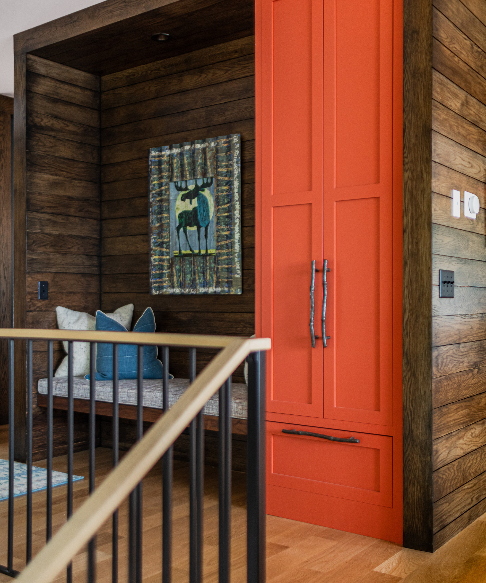 a sitting area with a bright orange cabinet