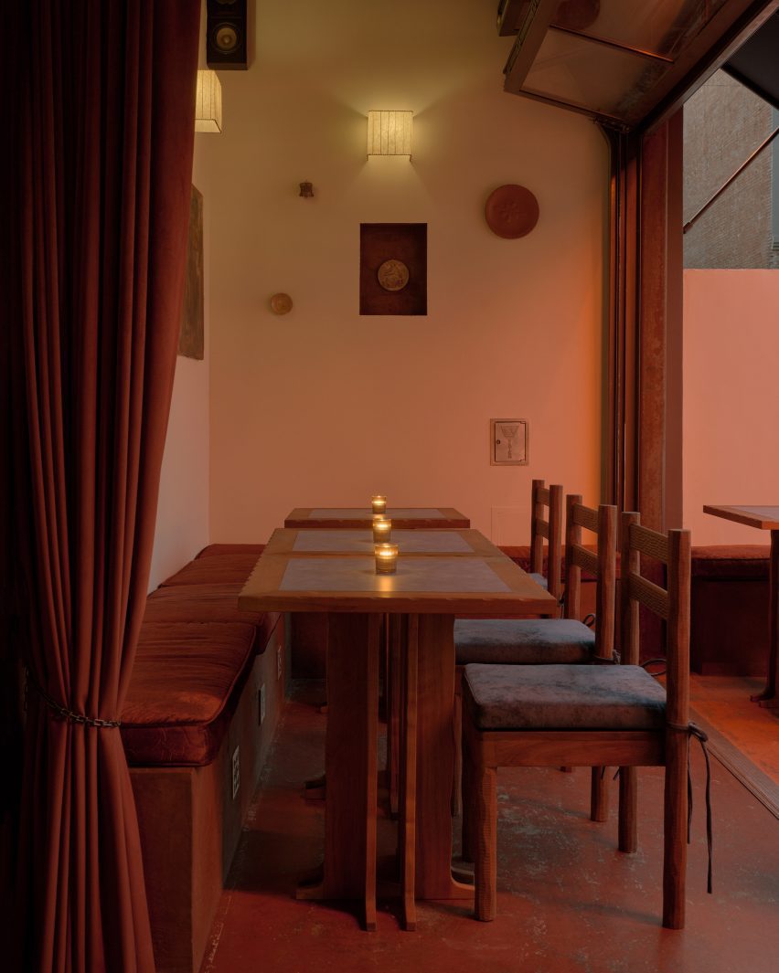 A dining area opened to an outdoor terrace via concerted glass panels