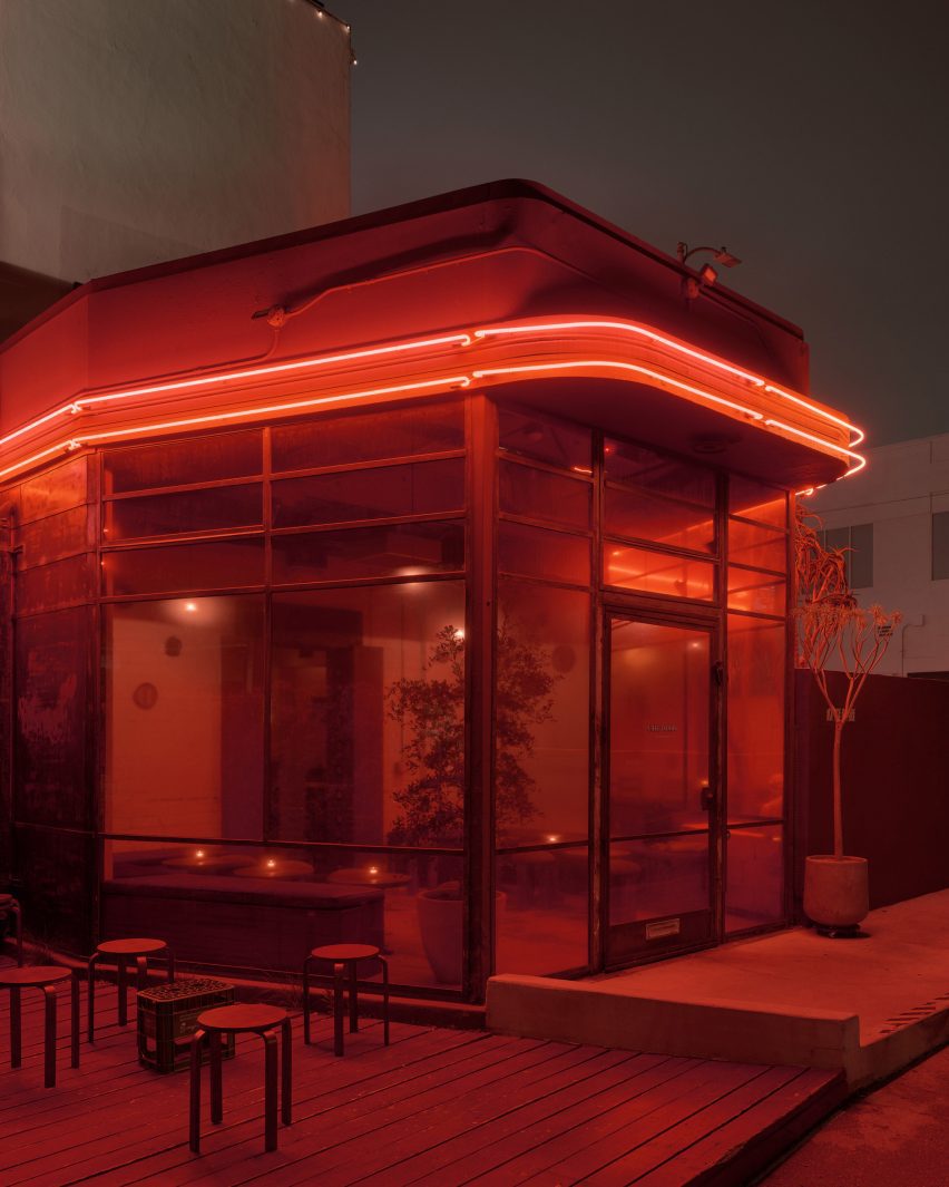 Red neon ribbons wrapped around the top of a building at night