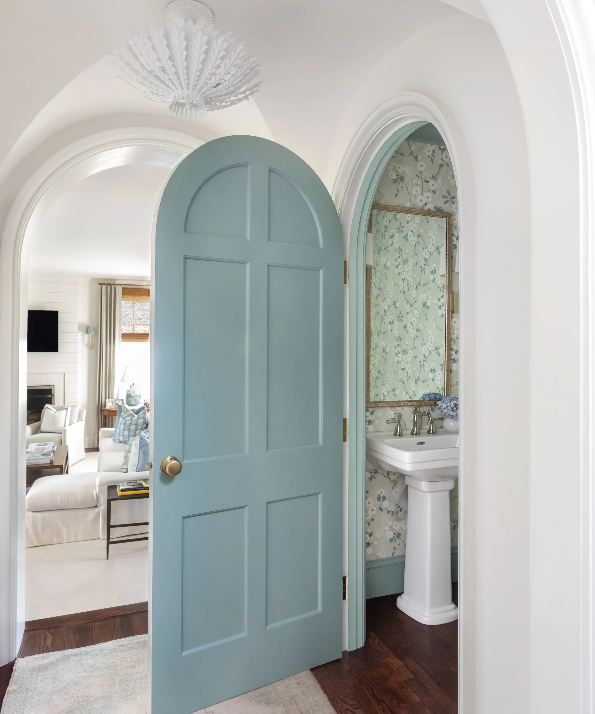 a blue door leading into a bathroom in a white hallway