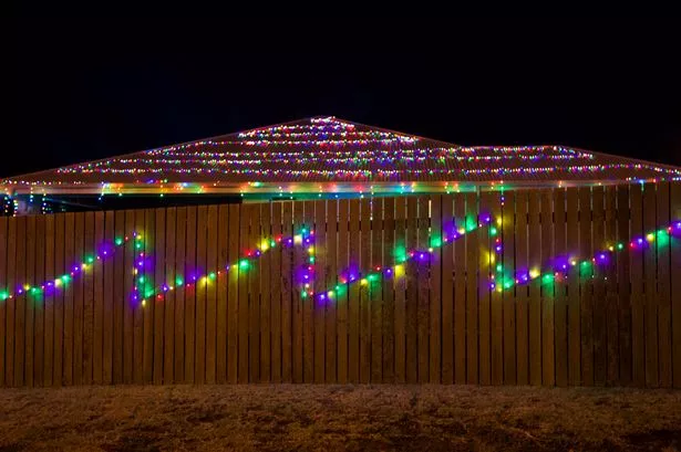 Colorful lights decorate a fence