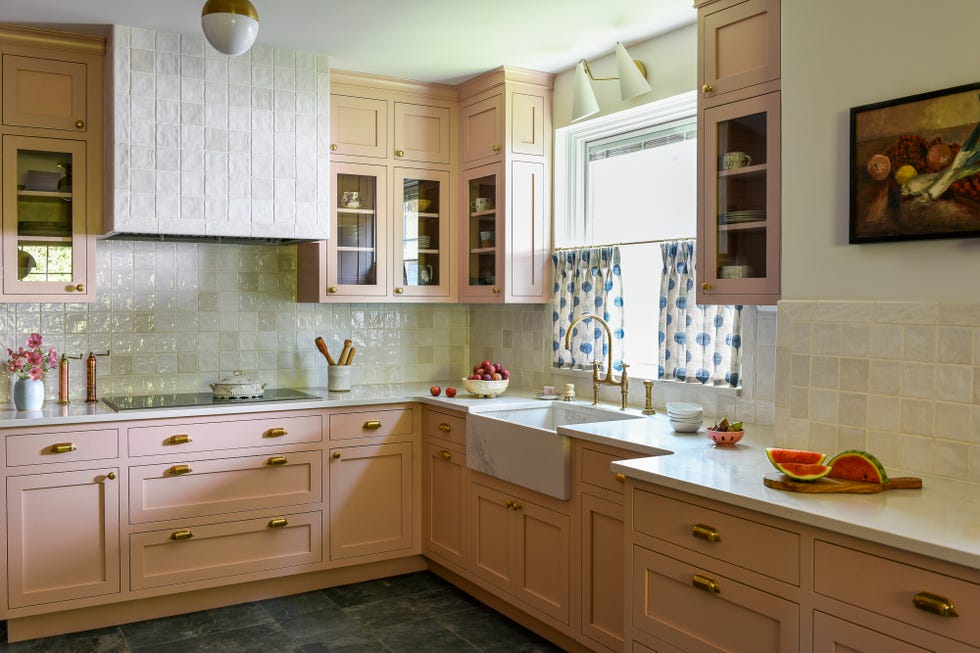Kitchen with pink cabinets and square tiles on the back wall and the extractor hood