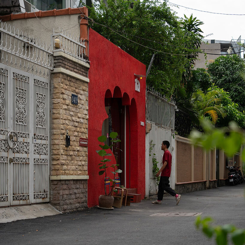 The red facade of the café creates an inviting hand-shaped entrance in Vietnam