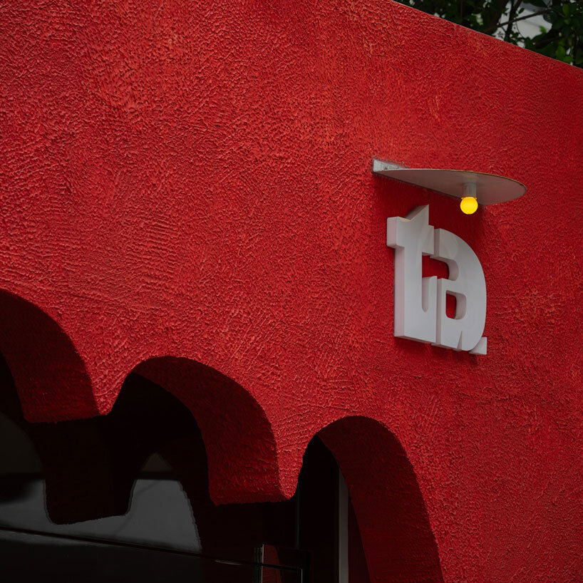 The red facade of the café creates an inviting hand-shaped entrance in Vietnam