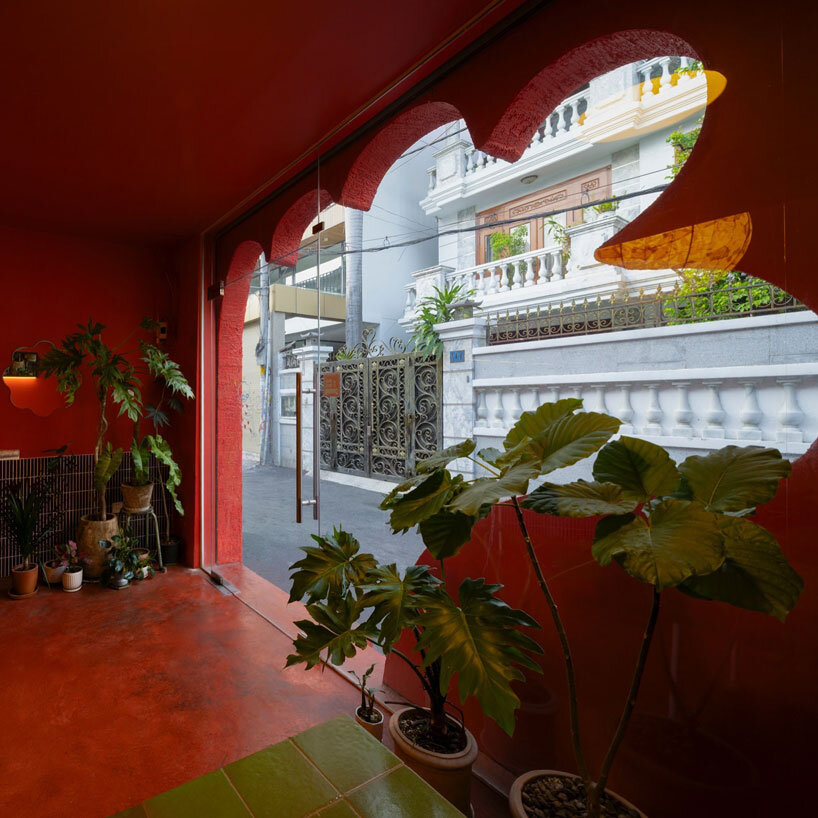 The red façade of the café creates an inviting, hand-shaped entrance in Vietnam
