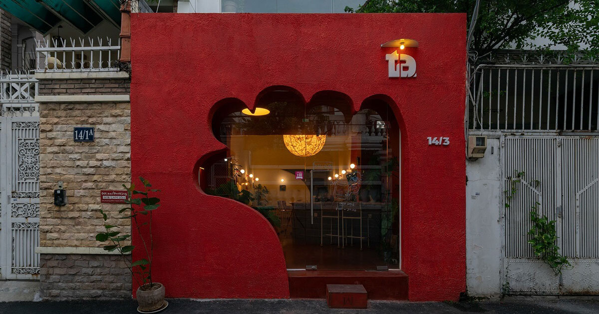 The cafe's red facade forms a hand-shaped entrance in Vietnam
