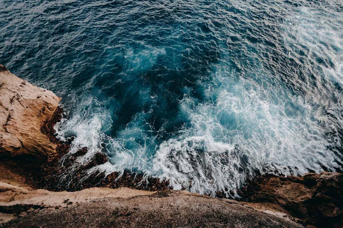 Aerial view of sea waves and rocky coast