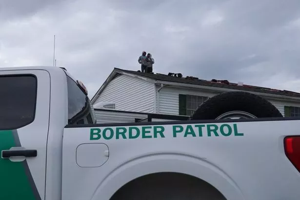 Construction workers refuse to come down from the roof after U.S. Border Patrol agents raided a construction site in Metairie, Louisiana, on December 3, 2025. 