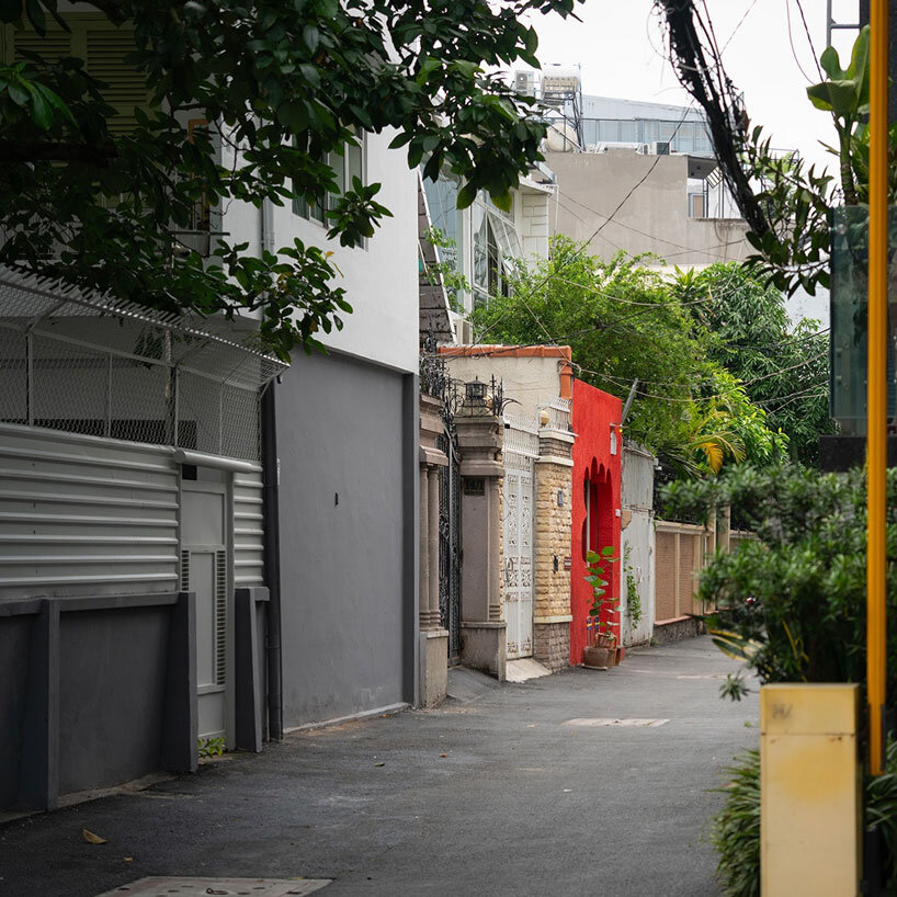 The red façade of the café creates an inviting, hand-shaped entrance in Vietnam